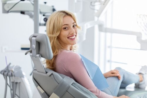 Smiling woman in dental chair at dental office in Pecan Grove