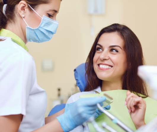 Woman grinning at her dental hygienist