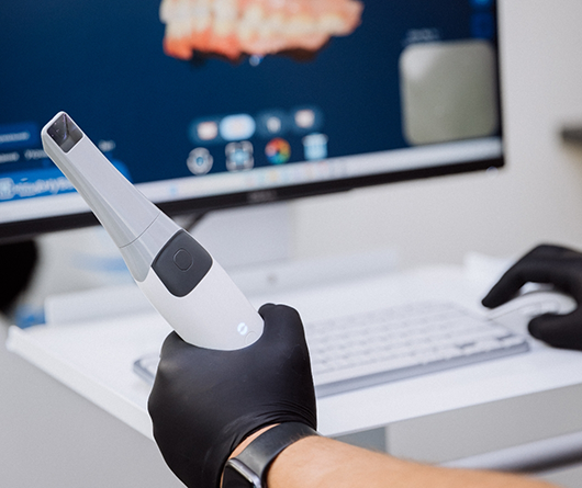 Dentist holding a camera device and looking at photos of teeth