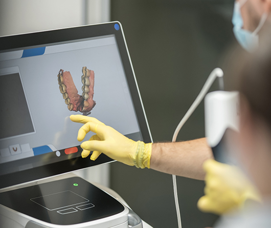 Dentist looking at digital impressions of a patient's teeth