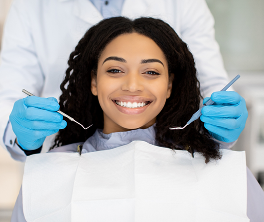 Woman grinning at her checkup with her Aetna dentist