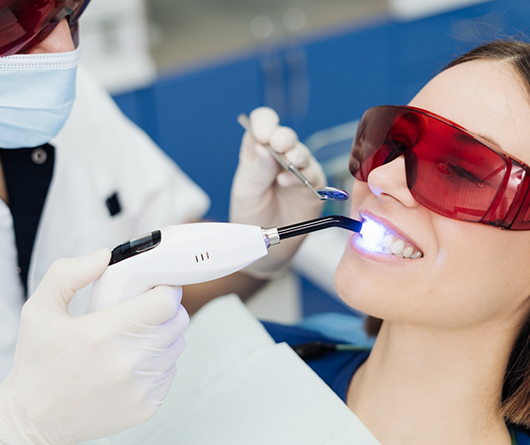Woman getting dental bonding on her front tooth