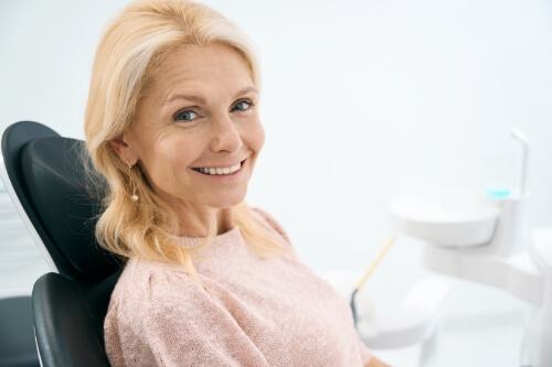 Smiling older woman sitting in dental chair