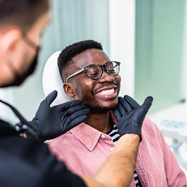 Dentist gesturing to a patient's smile