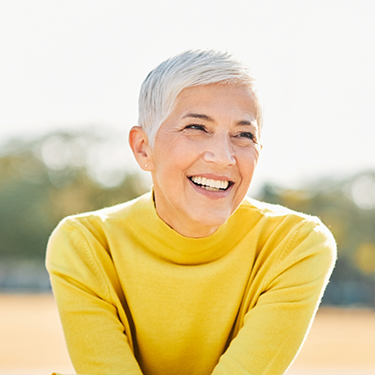 Older woman in a yellow sweater outside