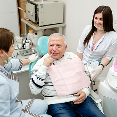 Senior man talking to his dental team