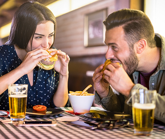 Man and woman eating burgers