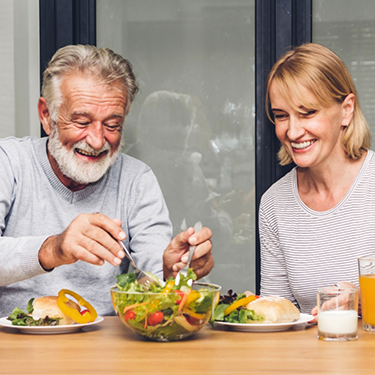 Older man and woman eating salad