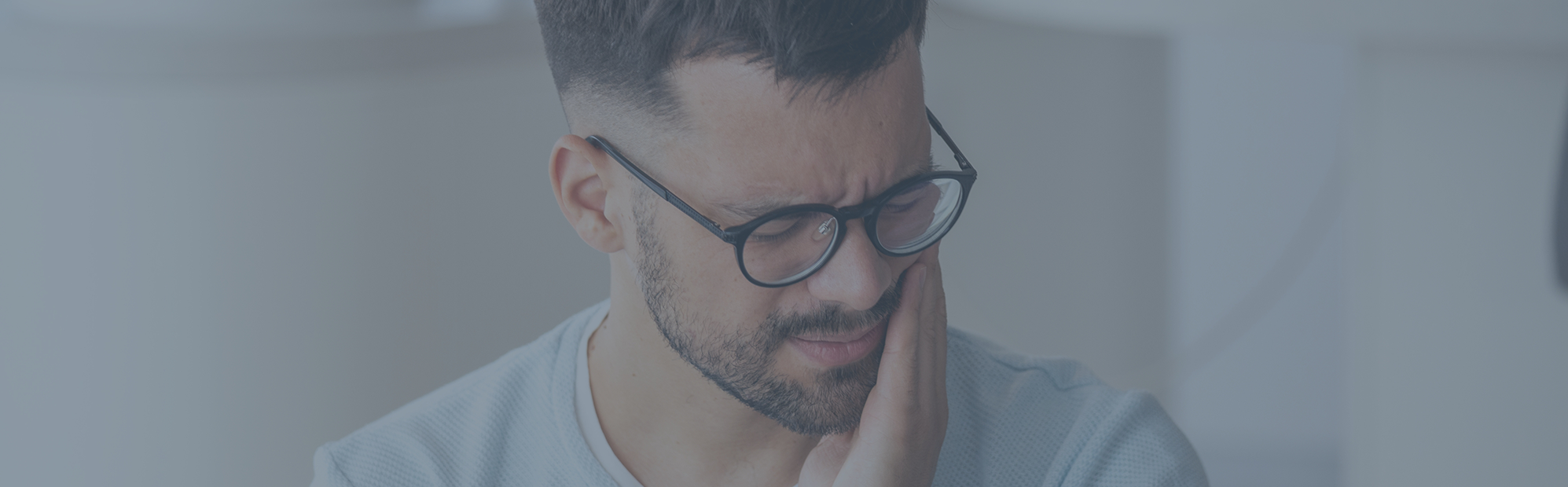 Young man holding the side of his face in pain