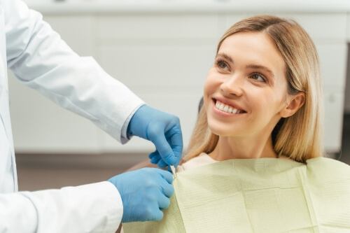 Woman smiling at her dentist after getting composite fillings in Pecan Grove