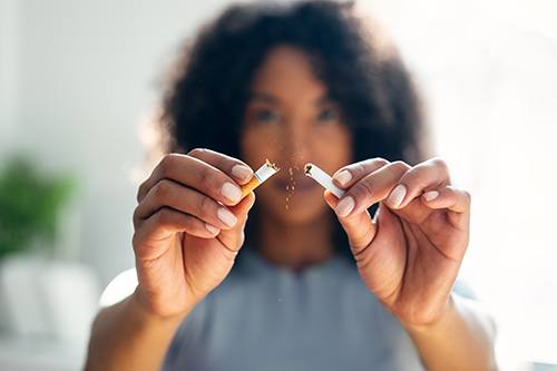 Woman snapping cigarette in half