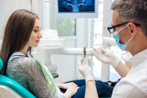 Dentist showing a dental implant to a patient