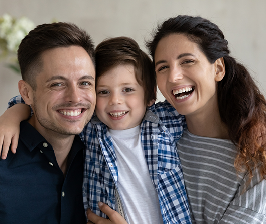 Smiling family of three at home