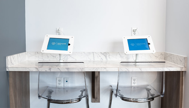 Countertop with two chairs and a tablet at each