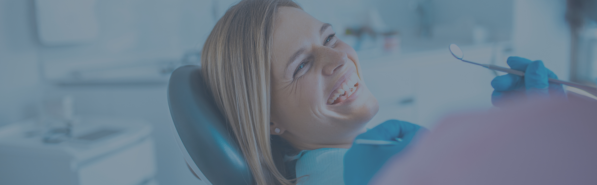 Woman grinning up at her dentist during a preventive checkup