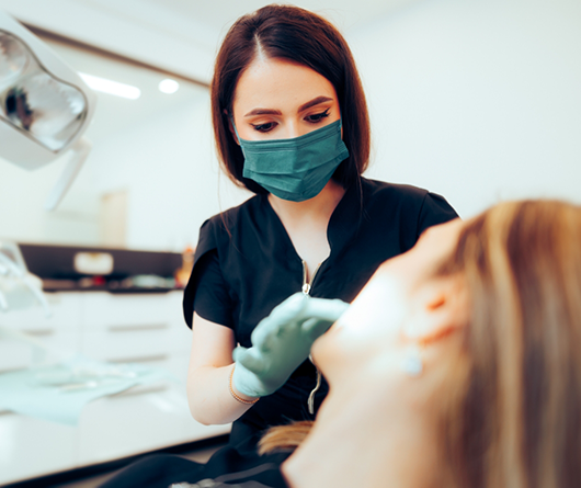 Dental team member looking into a patient's mouth