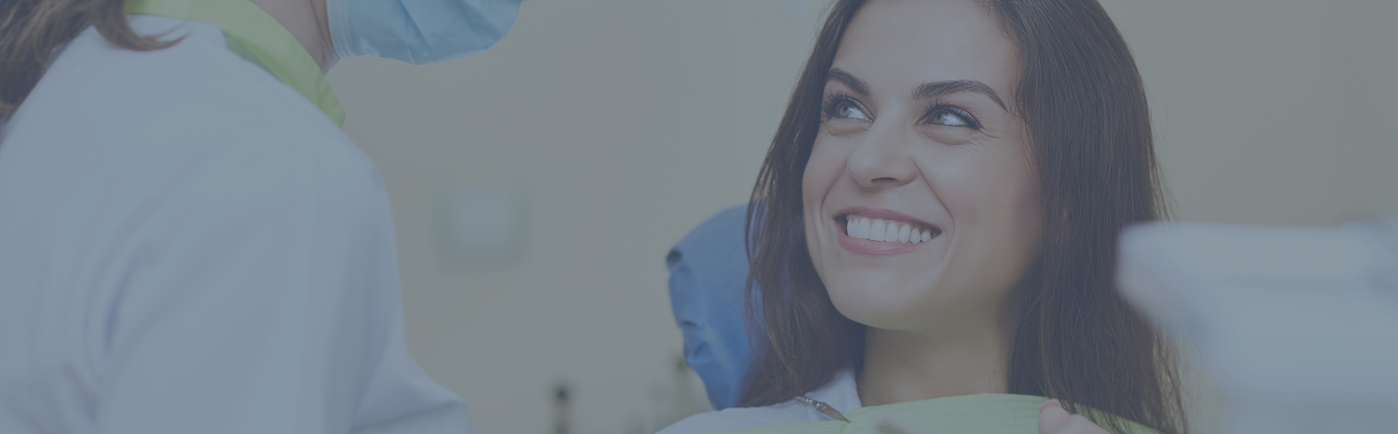 Woman grinning as her dentist prepares for her procedure