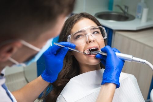 Young woman in dental chair receiving root canal treatment in Pecan Grove