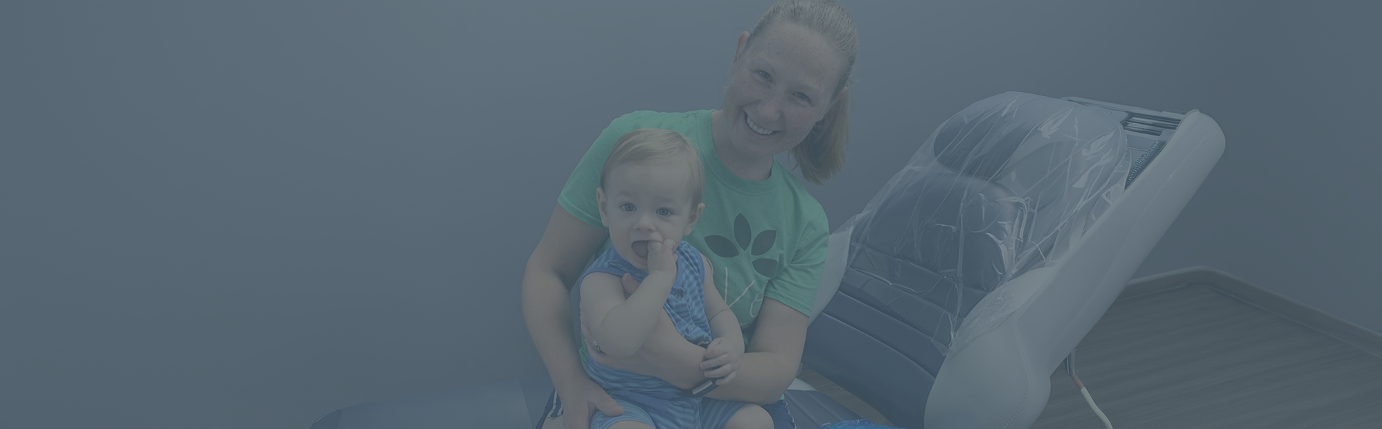 Mother bouncing her baby on her lap at the dentist