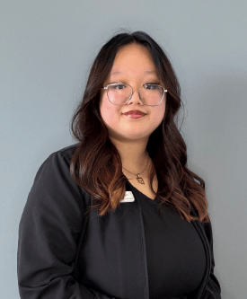 Lady smiles while forming the shape of a heart with hands