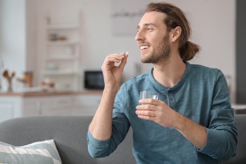 Patient taking a pain reliever after a dentist visit
